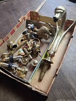 Box of assorted brass faucet parts with large swan spout