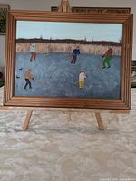 Full view of framed painting on easel
