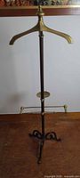 Full view of valet stand showing brass hanger, pole, and base