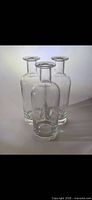 Three clear glass bottles grouped together