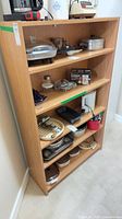 Front view of light wood MDF veneer bookcase with five shelves and miscellaneous contents (contents not included)