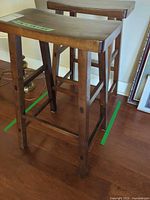 Two dark brown wooden counter stools backless view