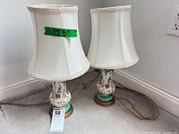 Full view of both lamps standing on carpet showing height tape and shades