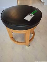 Overall view of stool showing seat upholstery and wood frame
