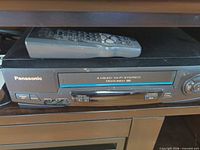 Panasonic VCR front panel with remote showing 4-head Hi-Fi Stereo Omnivision and front AV inputs