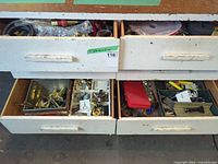 Four open drawers showing hoses, fittings, tools and hardware
