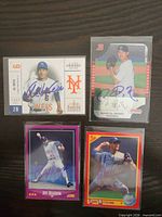 Group shot of four autographed baseball cards in sleeves