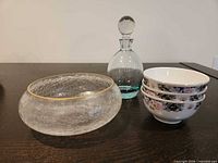 Group shot of crackle bowl, decanter and stacked porcelain bowls