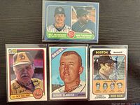 Group shot of the four signed cards in sleeves