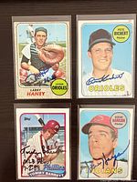 All four autographed Topps baseball cards in sleeves