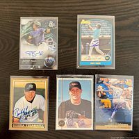 Group shot of all five autographed cards in sleeves