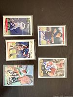 Overview of five signed baseball cards laid out on table