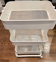 Front view showing three mesh trays and casters