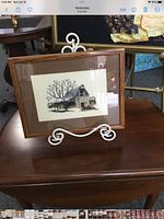 Full view of framed needlepoint on easel