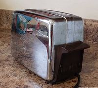 Oblique view showing chrome body, brown end panel with Dormeyer logo, attached cord