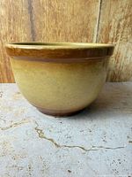 Side view showing yellow-tan glaze and brown rim