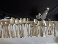 Front view of entire assortment laid out showing all flatware and glass shakers