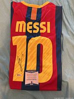 Back of jersey showing Messi name, number 10 with autograph, and Beckett COA card