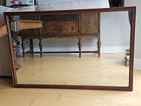 Front view of mirror showing wooden frame and clear glass