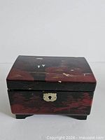 Front view closed showing metal escutcheon and painted landscape