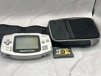 Front view of Nintendo Game Boy Advance console with carrying case and game cartridge displayed