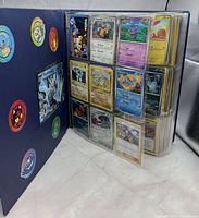 Binder standing open showing front character decals and first sleeve of nine cards