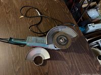Angle grinder with disc and detached guard on tabletop
