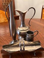 All four pewter items grouped: pitcher, bud vase, tankard, hammered footed tray