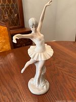 Front view of porcelain ballerina figurine on wood table