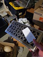 Front view of sealed silver vent cover with geometric cutouts