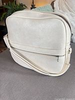 Front view showing exterior, front zip pocket, strap