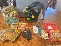 Overall view of microscope, books, comics, minerals, vernier dial and reel