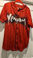 Front view of red Venom jersey on hanger