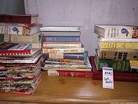Overall view of three stacks showing variety of hardcover, paperback, spiral and stapled cookbooks and medical guide