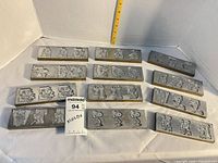 Front aluminum faces showing Peanuts character alphabet designs on 14 molds, ruler for scale
