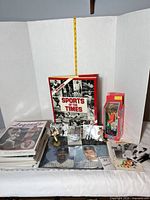 Overview of entire lot including book, magazines, bobblehead, baseball in case, figurines and photographs