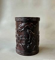 Front view showing carved tiger, figure, landscape and Greek-key border