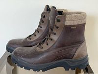 Side profile of both boots showing leather, stitching, lug sole