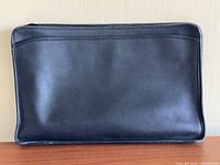 Front view of black leather portfolio showing monogram and overall exterior condition