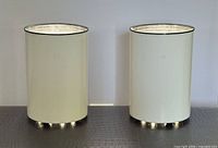 Both lamps lit, showing white enamel bodies with black rim