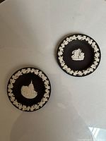 Both black Jasperware dishes showing designs