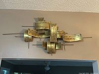 Front view of brass wall sculpture mounted on wall