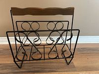Front view showing scrolled wrought iron sides and wood handle