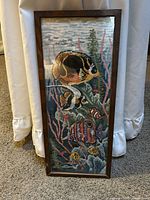 Front view of framed needlepoint showing tropical fish scene