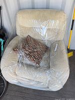 Front view of Lane beige microfiber recliner with pillow wrapped in plastic