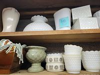 Shelf with milk glass pieces and ceramic planters