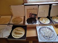 Overview of seven boxed plaques, certificates visible