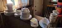 Stacked dinnerware set including plates, saucers, cups, serve pieces