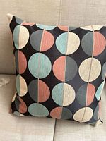Front view of multicolor geometric circle pillow showing pattern and overall condition