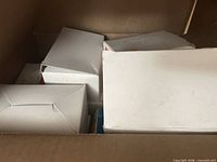 Overview of interior of shipping box showing multiple smaller sealed white boxes